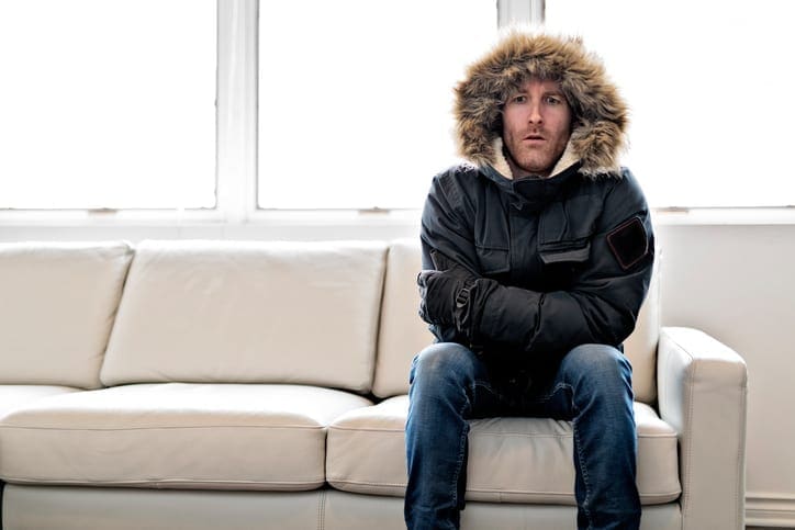 Kevin Robinson's Heating & Cooling | Lancaster, Kershaw, Lugoff, Camden, Indian Land, Heath Springs, SC | Man With Warm Clothing Feeling The Cold Inside House on the sofa